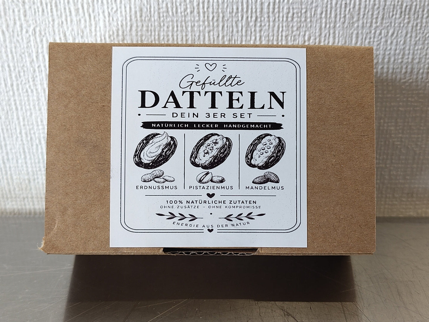Geschlossener Karton des diiszwii 3er Sets mit gefüllten Medjool Datteln in Bean-to-Bar Schokolade