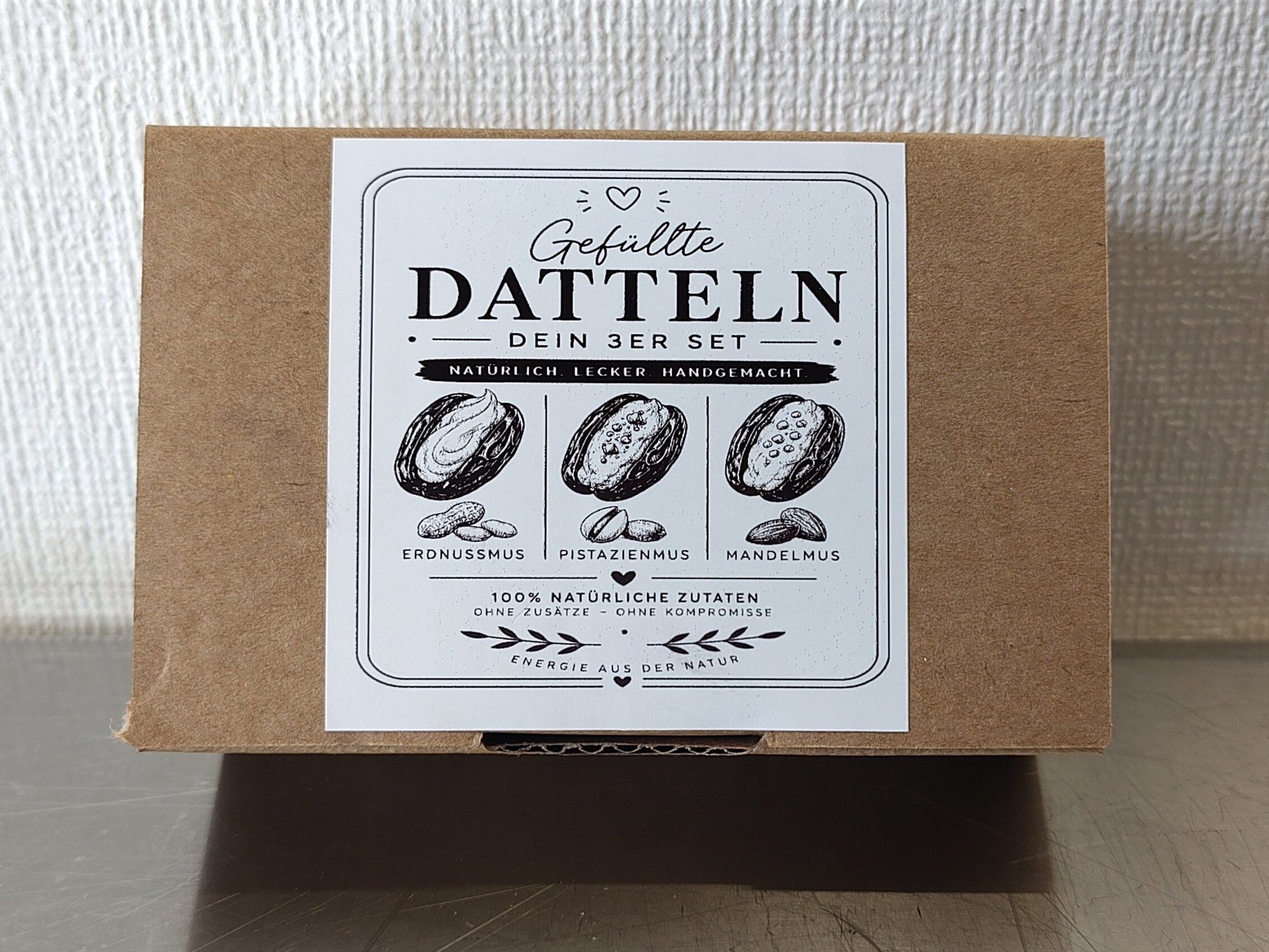 Geschlossener Karton des diiszwii 3er Sets mit gefüllten Medjool Datteln in Bean-to-Bar Schokolade