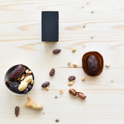 Gefüllte Dattel in Verpackung von oben, Schokolade & Zutaten rundherum sichtbar