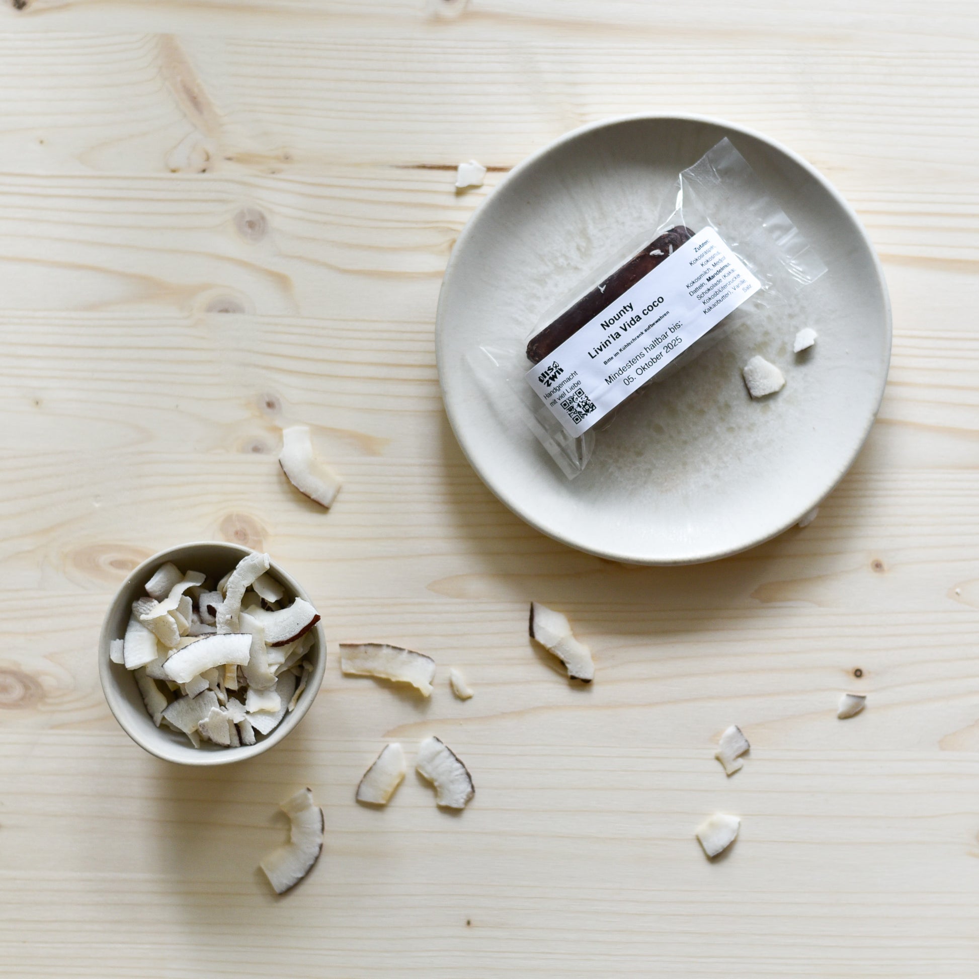 Verpackter Nounty Kokosriegel mit Zutaten – Datteln, Kokosraspeln und dunkler Schokolade