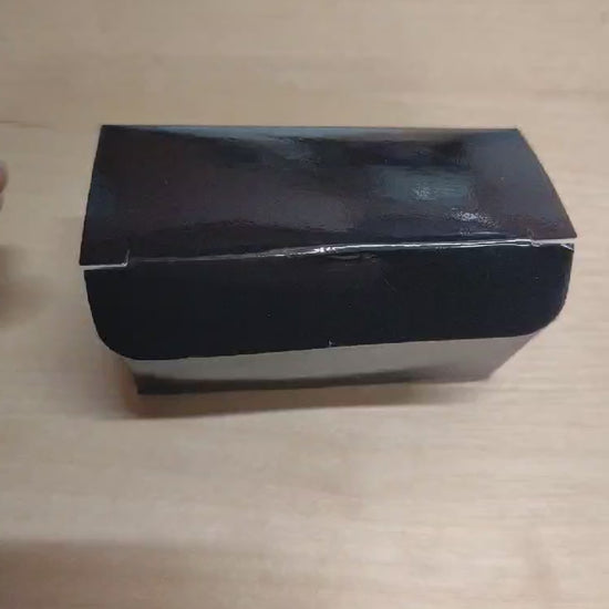 Video: Verpackung der gefüllten Dattel mit Erdnuss & Schokolade wird geöffnet – handgemachter Snack aus Medjool-Datteln, Erdnüssen, Schokolade & Salz