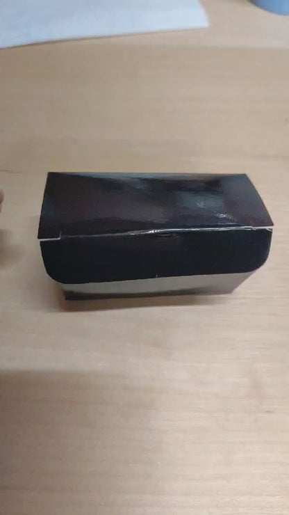 Video: Verpackung der gefüllten Dattel mit Erdnuss & Schokolade wird geöffnet – handgemachter Snack aus Medjool-Datteln, Erdnüssen, Schokolade & Salz