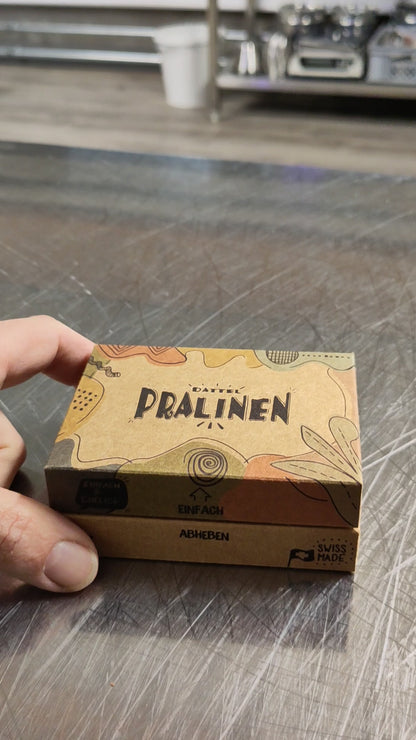 Video: 6er Pralinenbox wird geöffnet – handgemachte Dattel-Pralinen mit Schokolade auf Basis von Kokosblütenzucker, nachhaltig verpackt von Dilara
